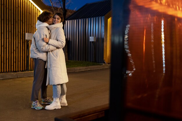 Couple embracing each other while outdoors at night