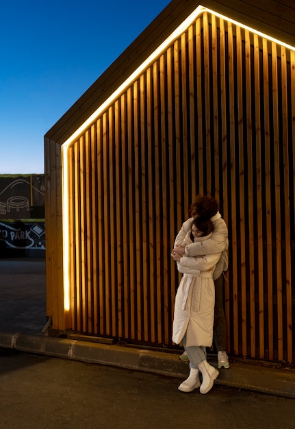 Couple embracing each other while outdoors at night