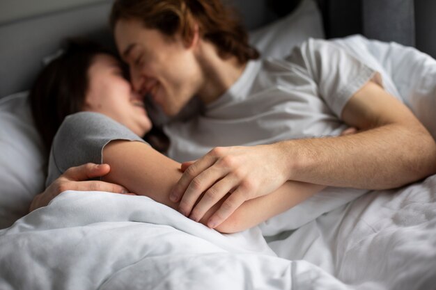 ベッドで愛情を込めて抱きしめるカップル