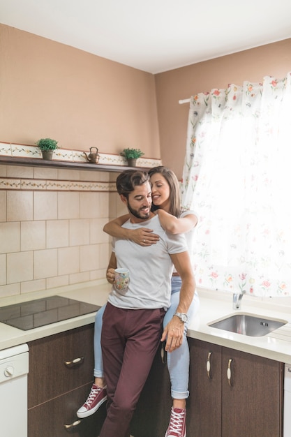 Couple embracing on kitchen in morning