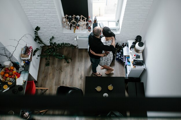 Couple embracing looking out of window as seen from above