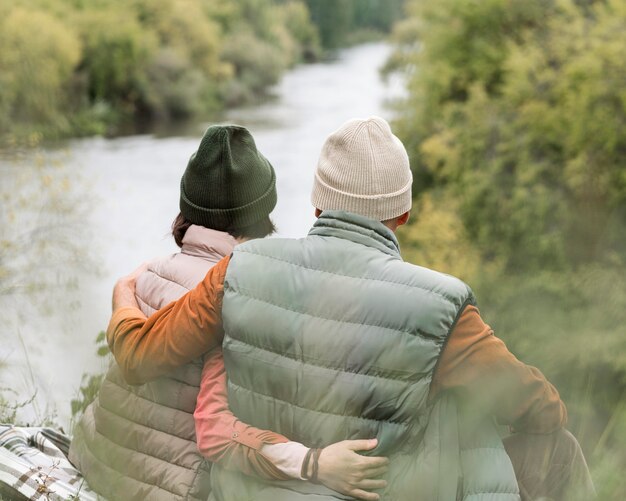 川を見て抱きしめるカップル