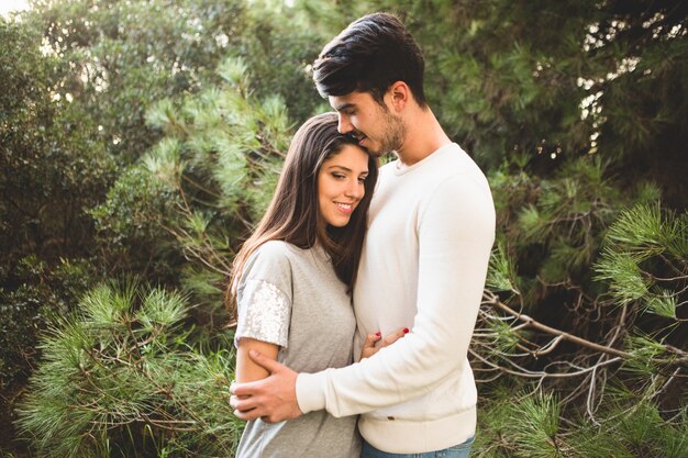 Couple embracing and the man kisses the woman in the hair