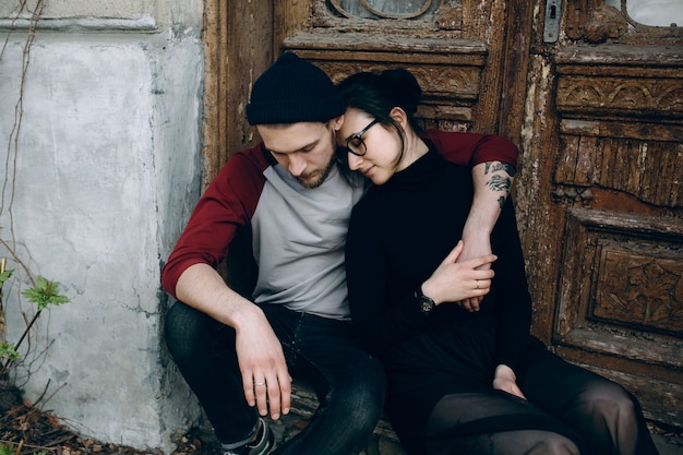 Free photo couple embracing next to an old door