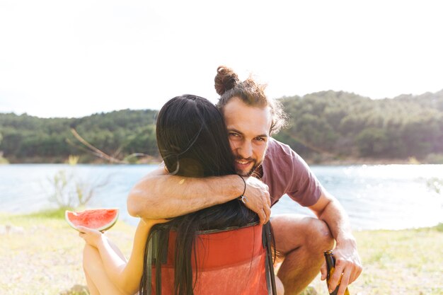 Couple embracing on riverbank
