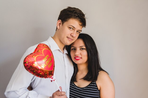 Free photo couple embracing with a heart shaped balloon