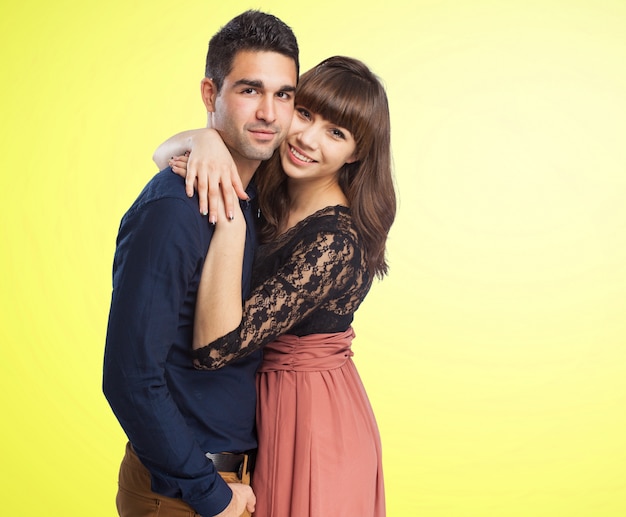 Couple embracing with a yellow background