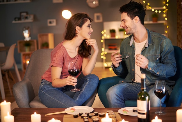 무료 사진 와인 한 잔과 함께 저녁을 즐기는 커플