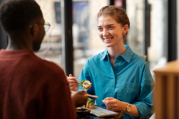 Free photo couple enjoying food in restaurant