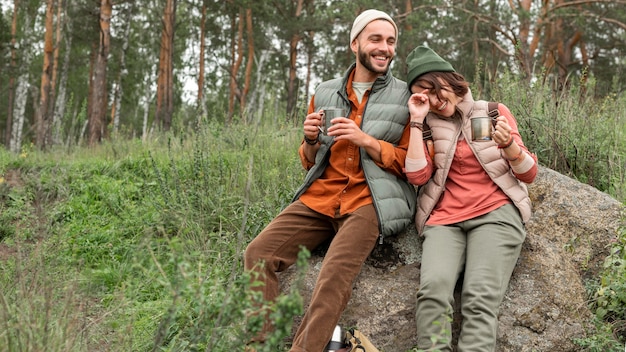 Free photo couple enjoying hot drink in nature