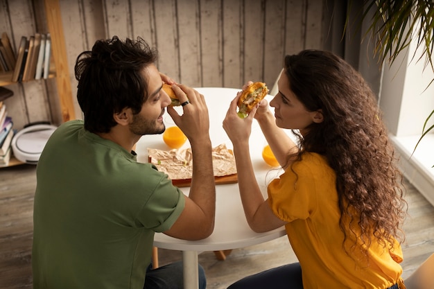무료 사진 집에서 샌드위치와 함께 점심을 즐기는 커플