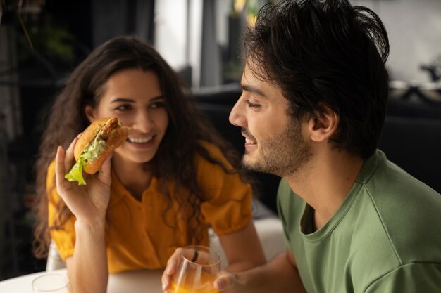 Couple enjoying lunch with sandwiches at home