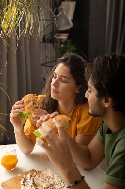 Couple enjoying lunch with sandwiches at home