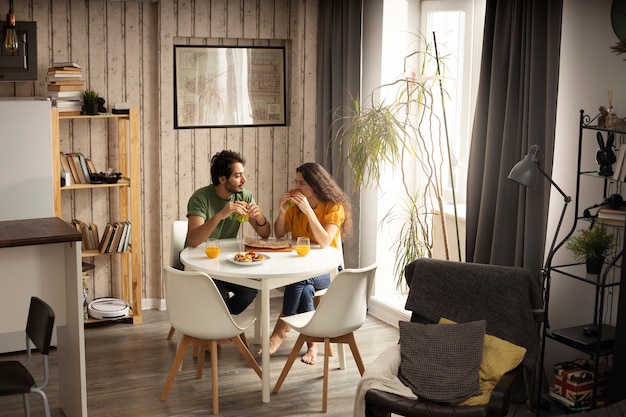 Couple enjoying lunch with sandwiches at home