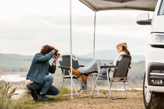 Couple enjoying nature while on a road trip with car and camera