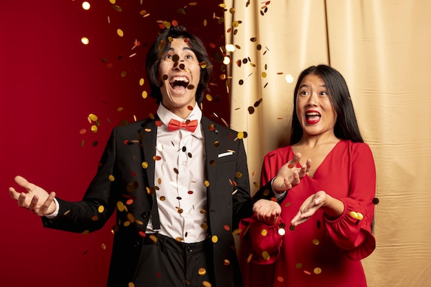 Couple enjoying throwing golden confetti