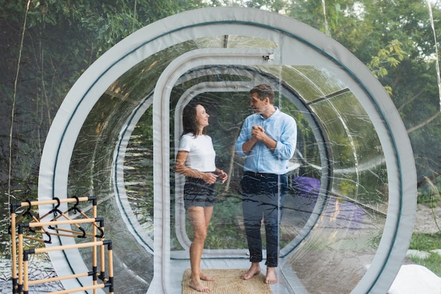 couple-entering-inside-transparent-bubble-tent-glamping-lush-forest-nature-around_1268-24580.jpg