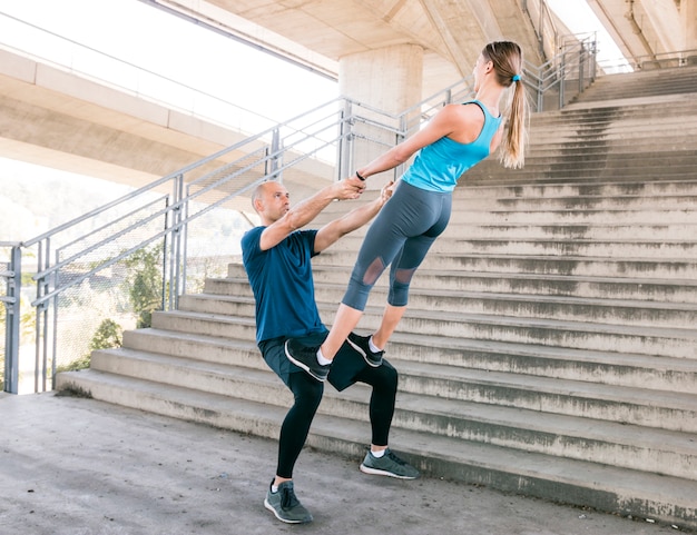 Couple exercising workout fitness aerobics posture near the staircase