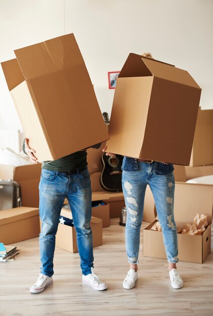 Couple faces behind cardboard boxes