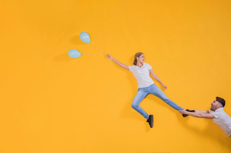 Free Photo couple floating in the air with balloons