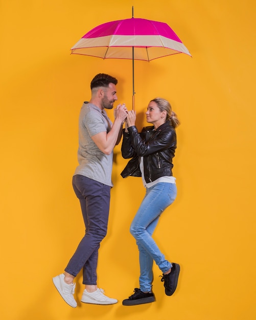 Free photo couple floating with an umbrella