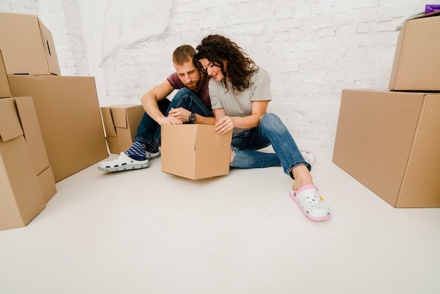 Couple on floor looking inside box