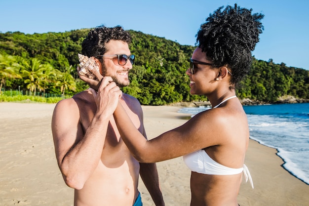 Free photo couple fooling with seashell