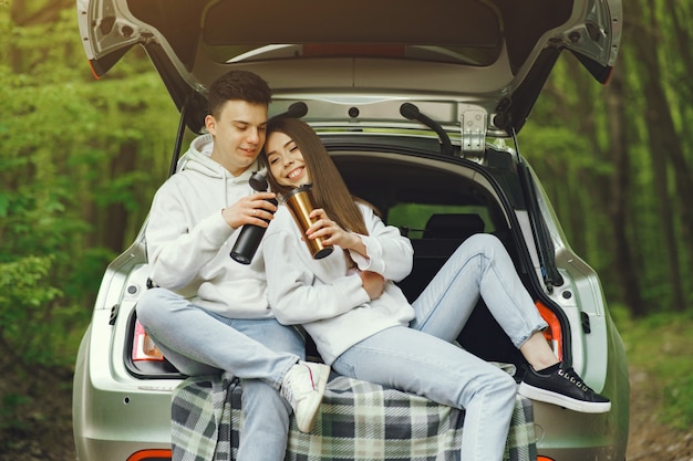 Free photo couple in a forest sitting in a trunk