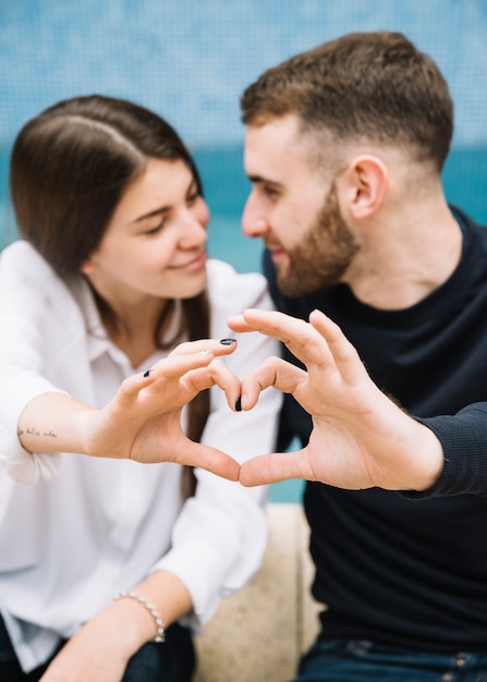 Couple forming heart with hands