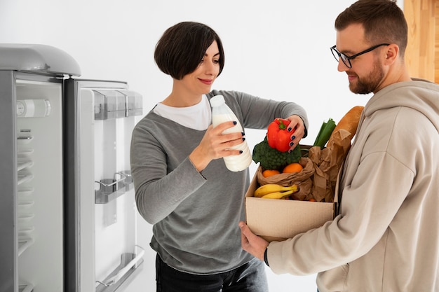 Foto gratuita coppia che riceve una consegna di generi alimentari