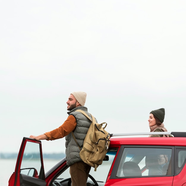 Free photo couple getting out of car in nature