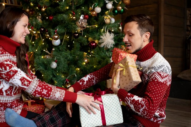 Couple giving each other christmas gifts