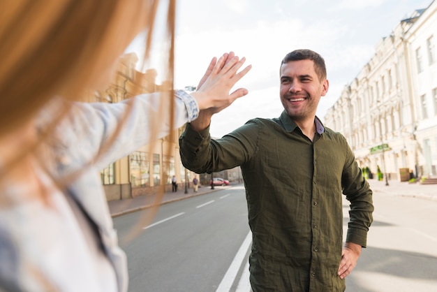 Couple giving high five on street