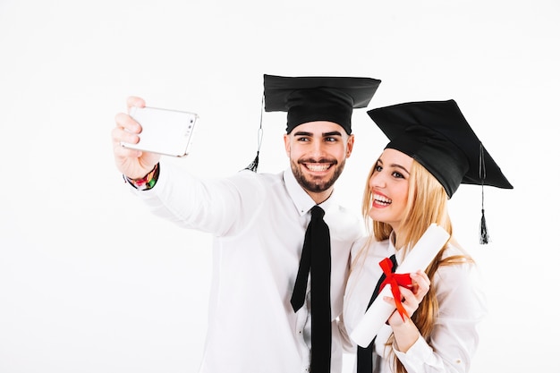 Free photo couple graduating and taking selfie