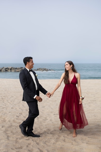 Couple in graduation prom clothing at the beach