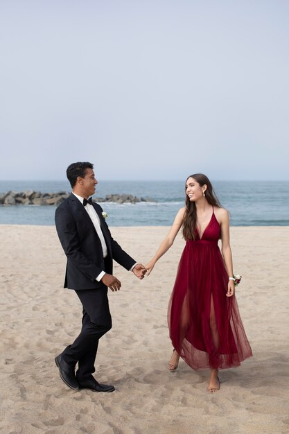 Пара в выпускной одежде выпускного вечера на пляже