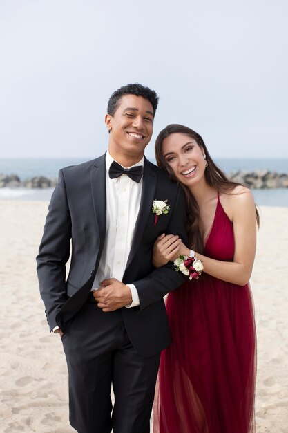 Couple in graduation prom clothing at the beach