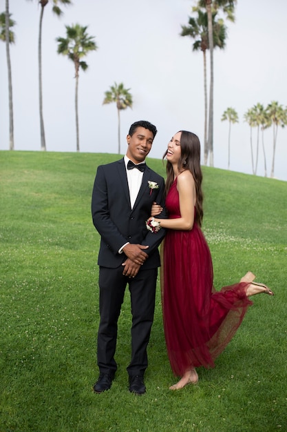 Couple in graduation prom clothing posing together