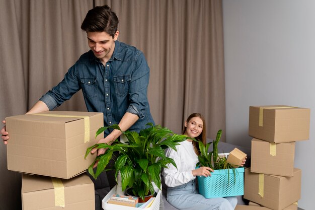 Couple handling boxes of belongings after moving in a new house