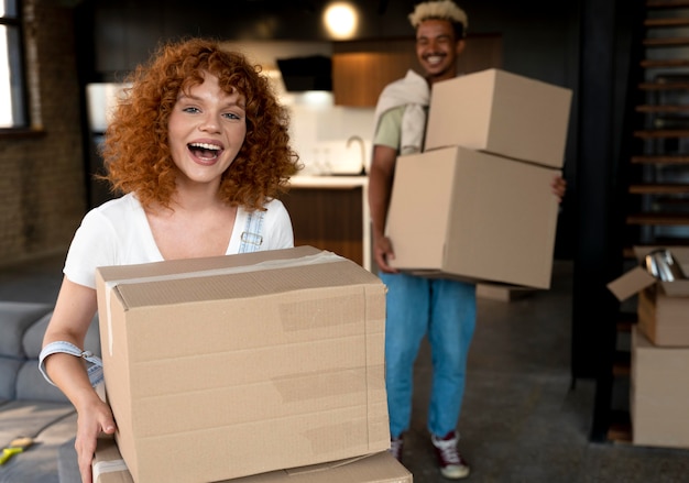 Free photo couple handling cardboard boxes with belongings after moving together in new home