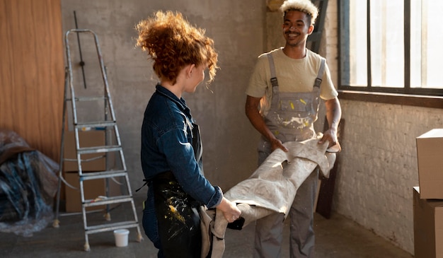 Free photo couple handling a carpet together in their new home