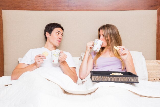 Couple having breakfast on bed