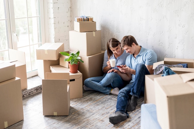 Couple having coffee while packing to move out of the house