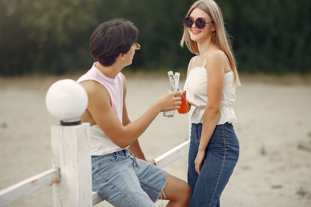Пара веселится на пляже с напитками