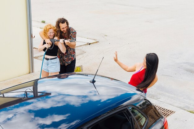 Couple having fun at car wash