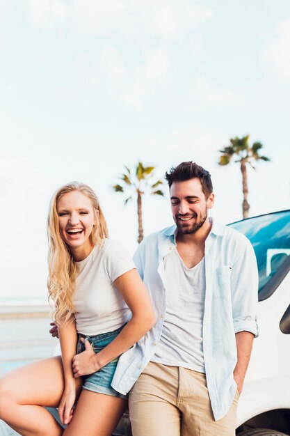 Couple having fun near car