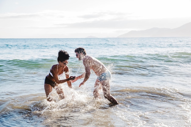 Couple having fun in the water at the beach
