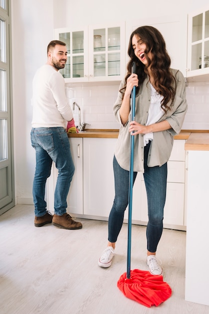 Couple having fun while washing kitchen