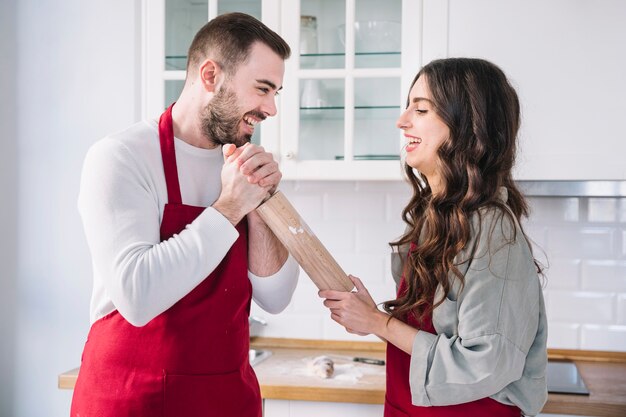 Couple having fun with rolling pin