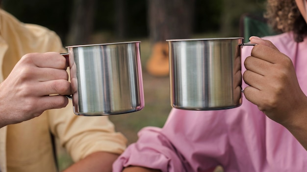 Couple having hot drinks while camping outdoors